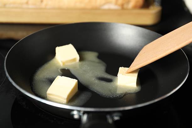 istock Stirring melting butter in frying pan on table, closeup 2245050287
