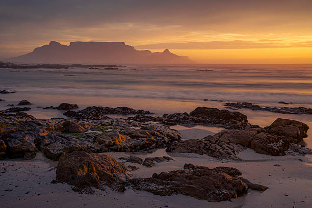istock Serene dusk panorama of Table Mountain, Lion's Head, and Devil's Peak silhouetted against a colorful sunset sky, from Kleinbaai Beach in Bloubergstrand, Cape Town, Western Cape, South Africa. 2245051000