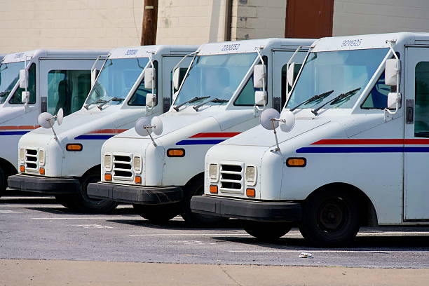 Miami, USA - June 26, 2025: A lineup of United States Postal Service trucks parked in a lot.