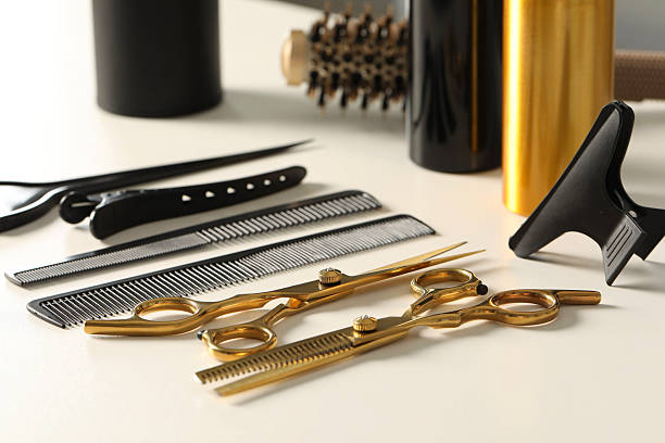 istock Hairdresser tools. Different scissors and combs on white table 2245055500