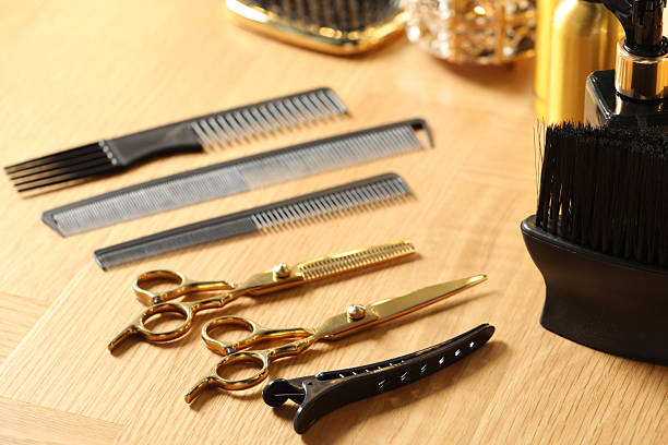 Hairdresser tools. Different scissors and combs on wooden table, closeup