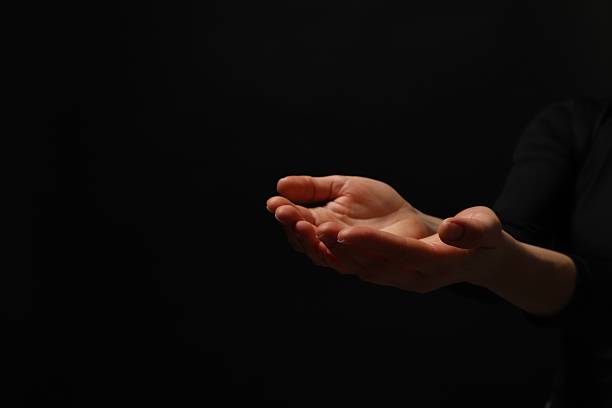istock Religion. Woman with open palms praying on black background, closeup. Space for text 2245059843