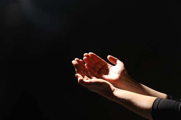 istock Religion. Woman with open palms praying on black background, closeup. Space for text 2245059857