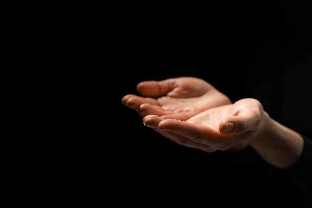 istock Religion. Woman with open palms praying on black background, closeup. Space for text 2245059900
