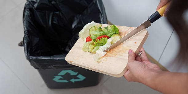 istock Eco-Friendly Practices: Woman Disposing of Vegetable Scraps Responsibly 2245060571