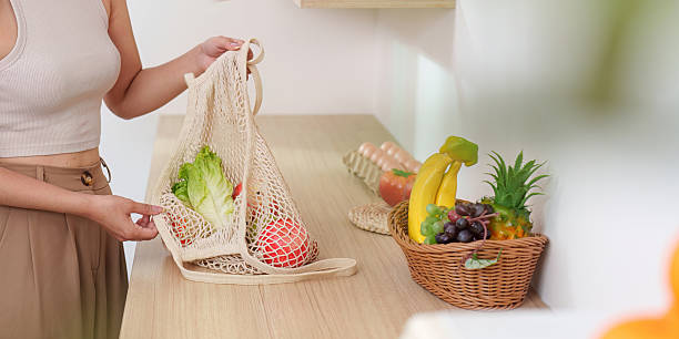 istock Eco-Friendly Choices: Woman Packing Fresh Produce in Reusable Bag 2245060604