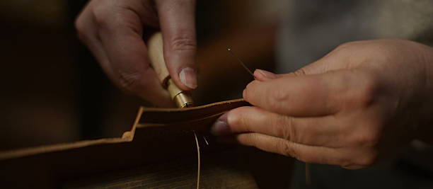 istock Hands stitch leather with awl and thread in a focused workspace 2245061799