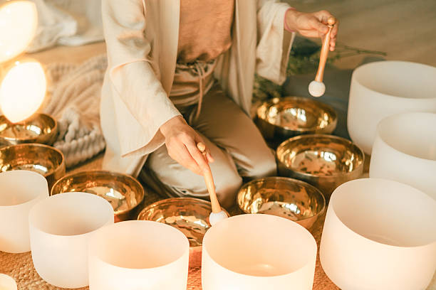 istock Sound healing practitioner playing crystal and brass bowls in a peaceful warm wellness setting 2245062246