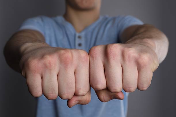 Man showing fists with space for tattoo on grey background, selective focus