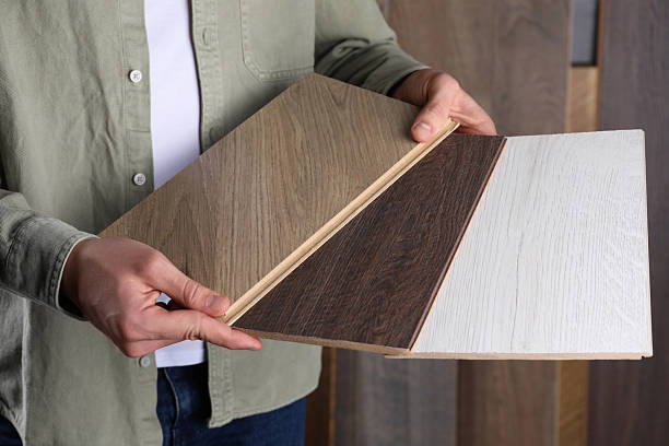 istock Man with different samples of wooden flooring indoors, closeup 2245065545