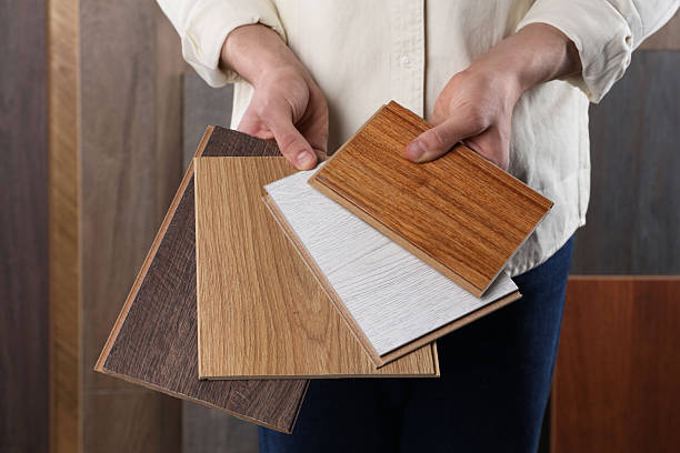 istock Man with different samples of wooden flooring indoors, closeup 2245065548