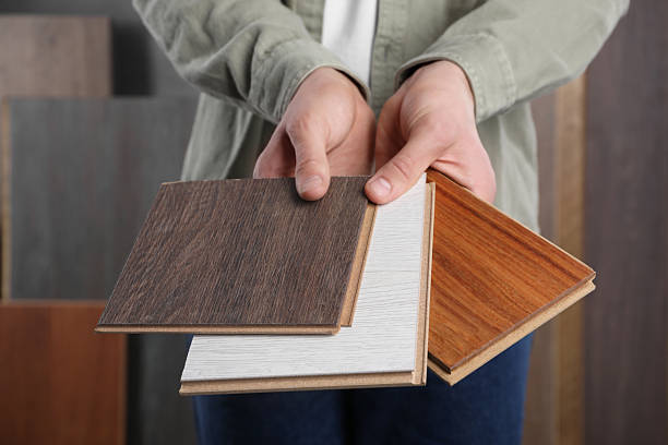 istock Man with different samples of wooden flooring indoors, closeup 2245065588