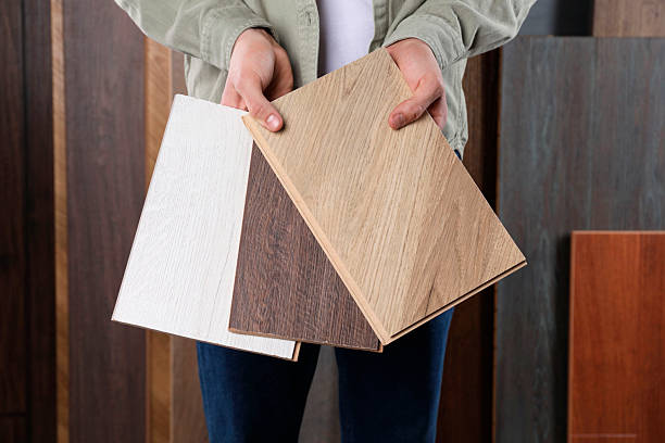 istock Man with different samples of wooden flooring indoors, closeup 2245065593