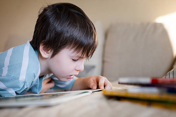 istock Curious young boy reading a book at home, focused on the page during a quiet learning moment 2245066925