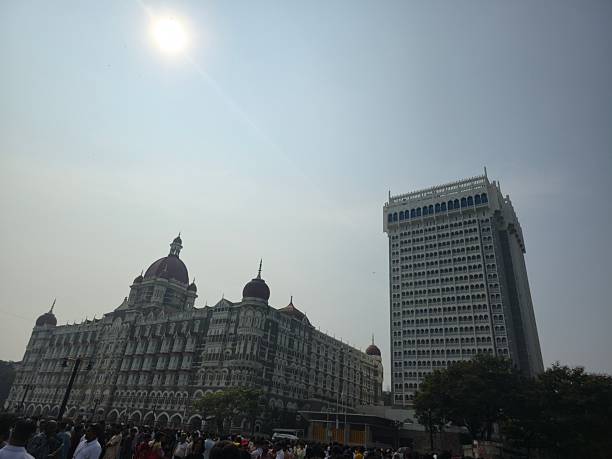 Elegant view of iconic buildings with red domes illuminated by morning sunlight. Classic Indo-Saracenic architecture stands tall against clear blue sky symbolizing heritage and grandeur of Mumbai skyline.