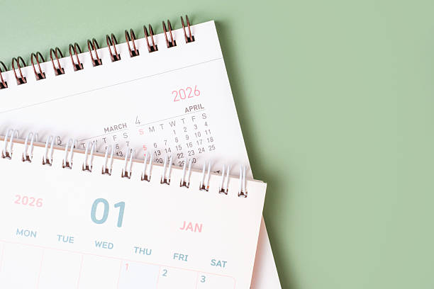 istock Paper calendars for 2026 on green background close-up, top view. 2245069115