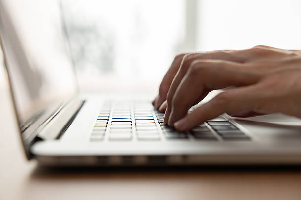 istock Woman’s hands typing on laptop at a wooden desk 2245071315