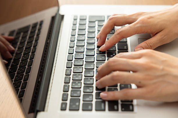 istock Woman’s hands typing on laptop at a wooden desk 2245071421