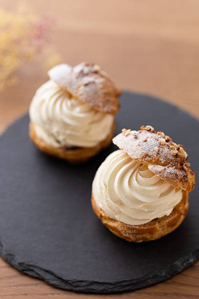 istock Cream puffs with whipped cream filling on a white plate 2245071487
