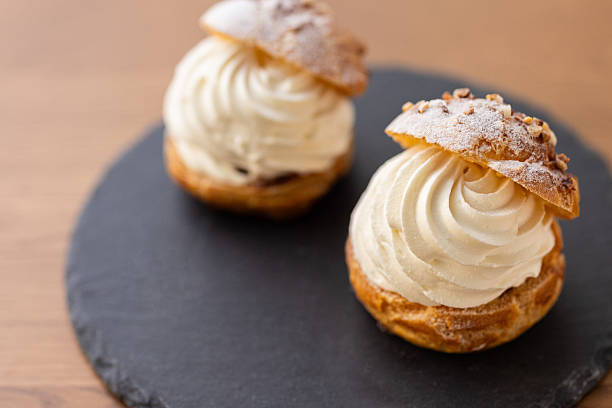istock Cream puffs with whipped cream filling on a white plate 2245071498