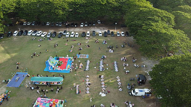 istock Community gathering outdoors featuring fun activities, tents, and picnics in a vibrant park, perfect for family events and social celebrations 2245071952