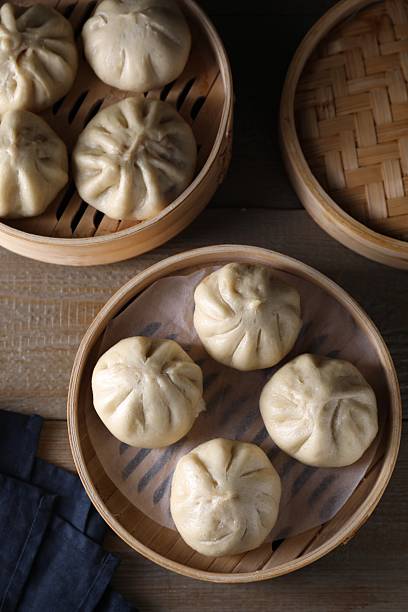 istock Delicious bao buns (baozi) on wooden table, flat lay 2245072183