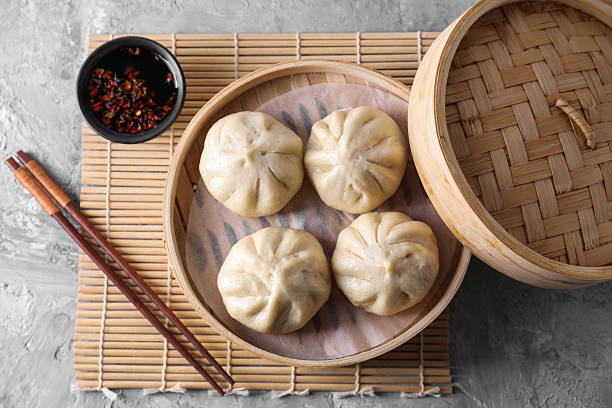 istock Delicious bao buns (baozi), chopsticks and sauce on grey textured table, flat lay 2245072225