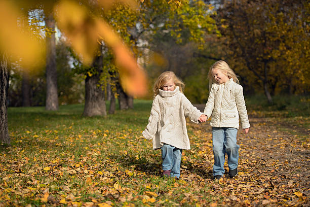 istock Two sisters walking through an autumn park holding hands 2245075178
