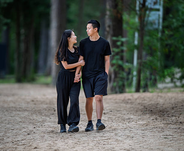 istock Young 20's Chinese Asian Couple Smiling While Enjoying a Walk Through the Forest Park 2245079273
