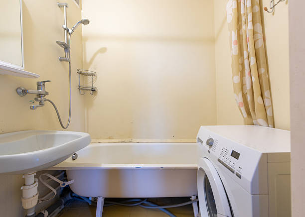 istock Compact Bathroom Interior With Bathtub, Sink, and Washing Machine 2245080604