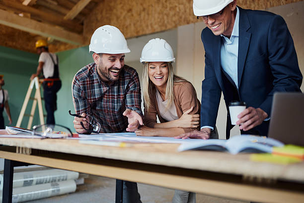 istock Happy couple reading plans with an architect at construction site. 2245087648