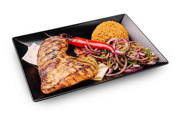Close up of grilled chicken with white rice and sambal matah on a white plate