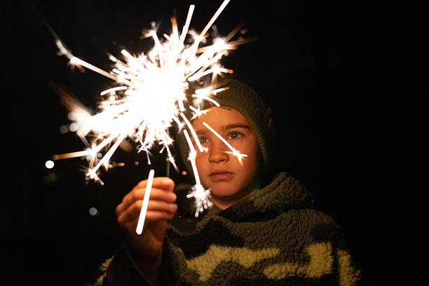 istock Boy holding lit sparkler celebrating at night 2245094889