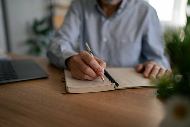 istock Senior man writing notes in personal journal at home 2245094985