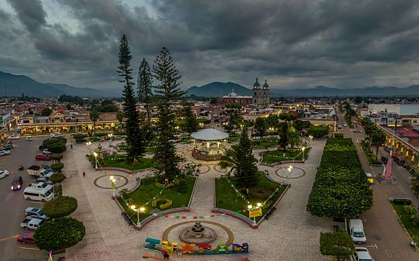 istock Vibrant town square at dusk with church and mountains. 2245097427