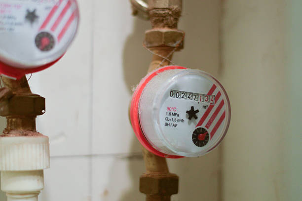 A water meter installed on a pipeline, measuring the flow rate and volume of either cold or hot water passing through the system for utility monitoring purposes.