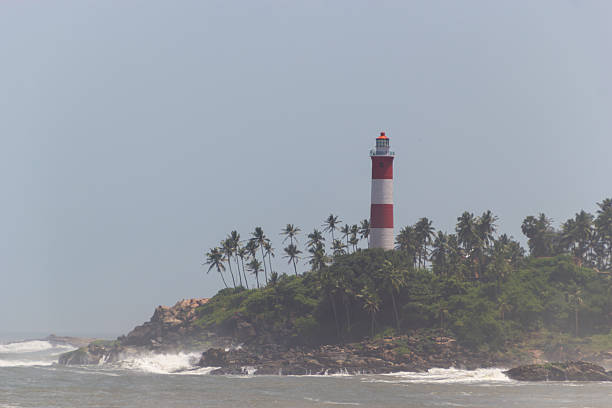 istock Striking Red and White Lighthouse on a Lush, Palm-Covered Island Headland 2245098731