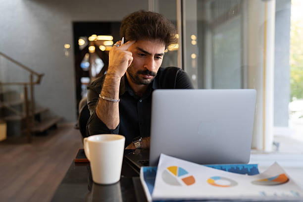 istock Thoughtful businessman analyzing market data charts on laptop 2245099518
