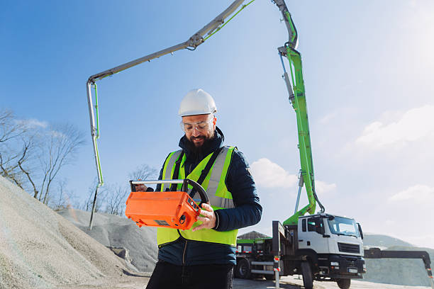 istock Construction worker operating concrete pump truck at production plant 2245099707