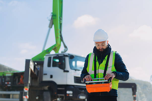 istock Construction worker operating concrete pump truck remote control at plant 2245099754