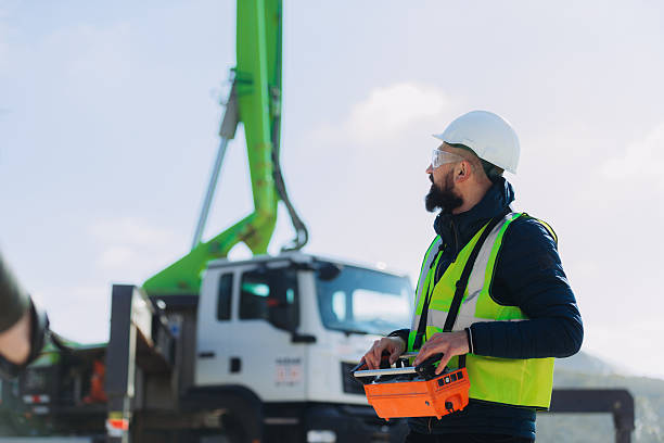 istock Construction worker operating concrete pump truck with remote control at plant 2245099756