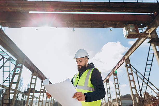 istock Construction engineer examining blueprint at concrete production plant 2245100253