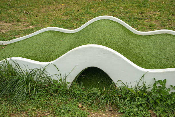 A young boy playing mini golf