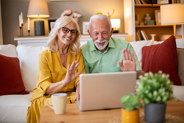 istock Senior couple video calling on laptop, waving hands 2245103885