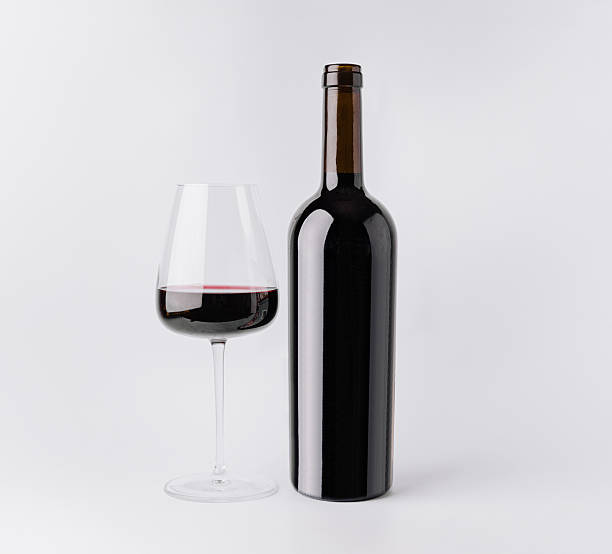 istock Enjoying red wine in a glass beside a bottle on a white background 2245106834