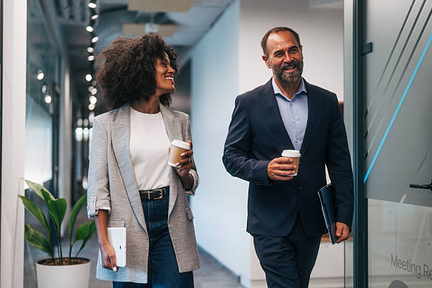 istock Diverse business colleagues walking in office, smiling, talking 2245108542