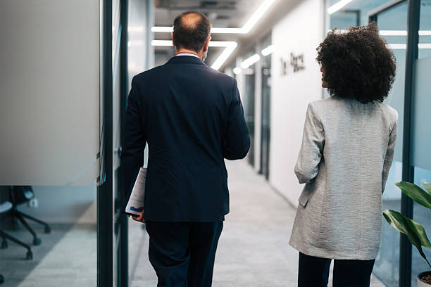 istock Business colleagues walking through office hallway during workday 2245108737