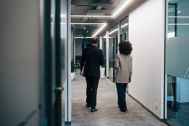 istock Business colleagues walking through modern office hallway 2245108797