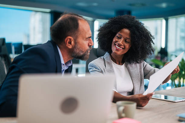 istock Business partners collaborating in office meeting discussing documents 2245109099
