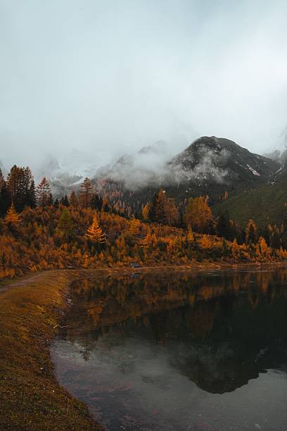 istock Autumn landscape with misty mountains and lake. 2245109345